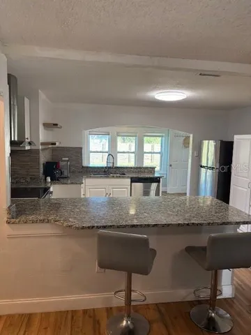 a view of a living room and kitchen with furniture