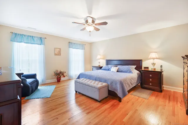 a spacious bedroom with a bed and wooden floor