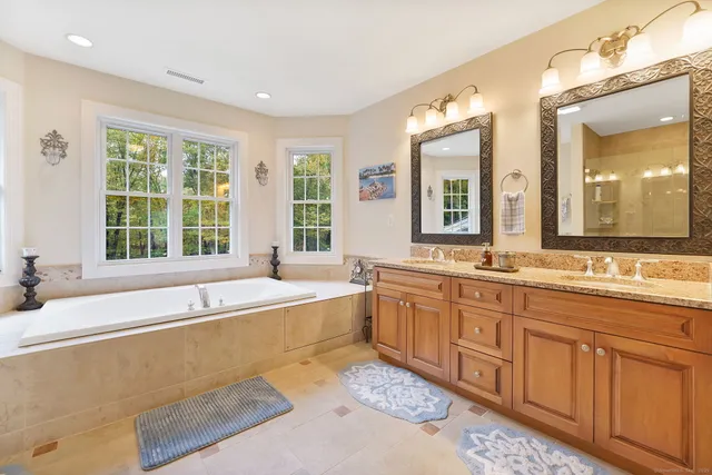 a spacious bathroom with a large tub sink and mirror