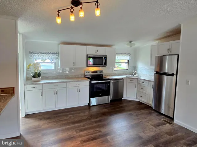 a kitchen with a refrigerator and a stove top oven