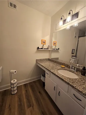 a bathroom with a granite countertop sink and a mirror