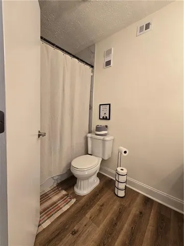 a bathroom with a toilet and a shower curtain