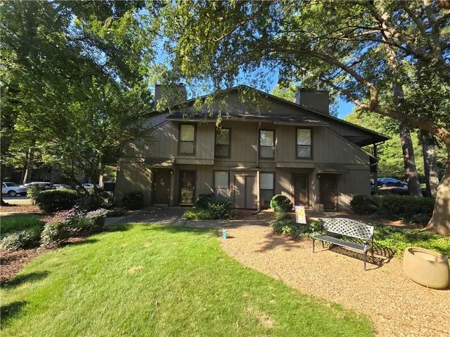 a view of a house with yard and sitting area