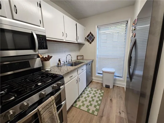 a kitchen with stainless steel appliances a stove a sink and cabinets