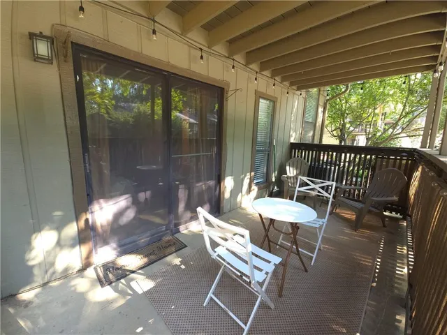 a view of a porch with furniture and floor to ceiling window