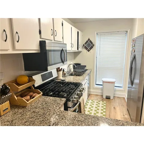 a kitchen with a stove a refrigerator and cabinets