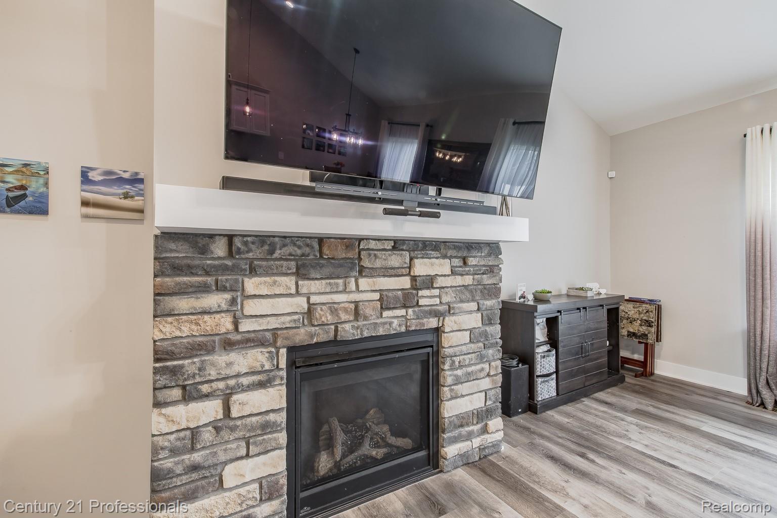 4914 TORATOLA Lane Howell, MI 48843 - Photo 12 of 39 Detailed view of wood finished floors and a fireplace