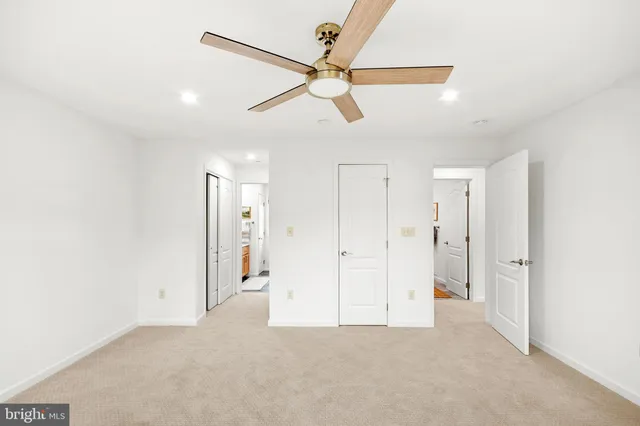 a view of a room with a ceiling fan and window