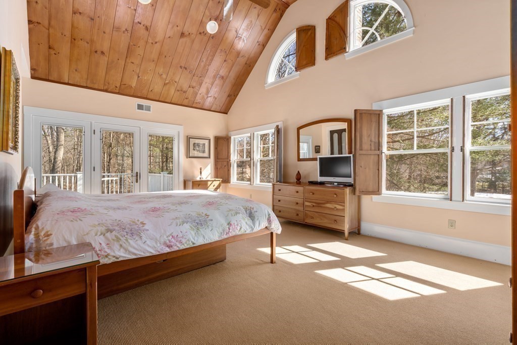 9 Lantern Lane Natick, MA 01760 - Photo 20 of 42 a spacious bedroom with a bed and a large window with balcony view