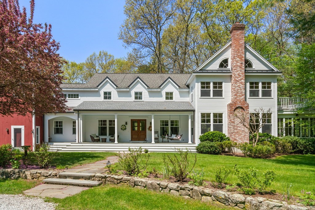 9 Lantern Lane Natick, MA 01760 - Photo 2 of 42 a view of a white house next to a yard with plants and trees