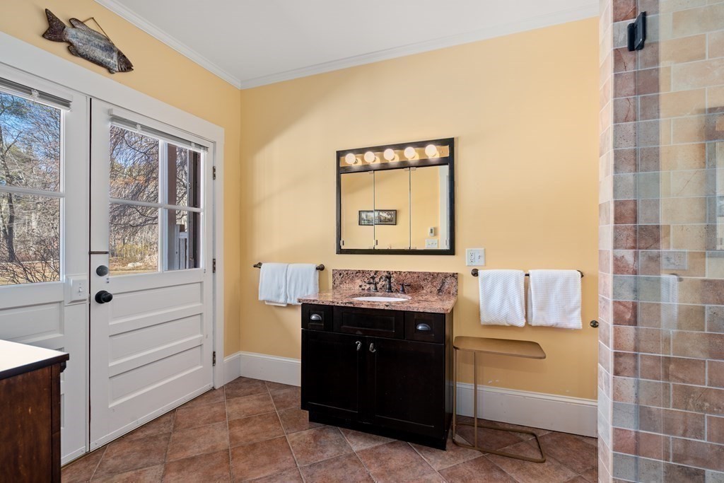 9 Lantern Lane Natick, MA 01760 - Photo 31 of 42 a bathroom with a granite countertop sink a mirror and a bathtub