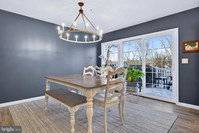 a dining room with furniture a chandelier and wooden floor