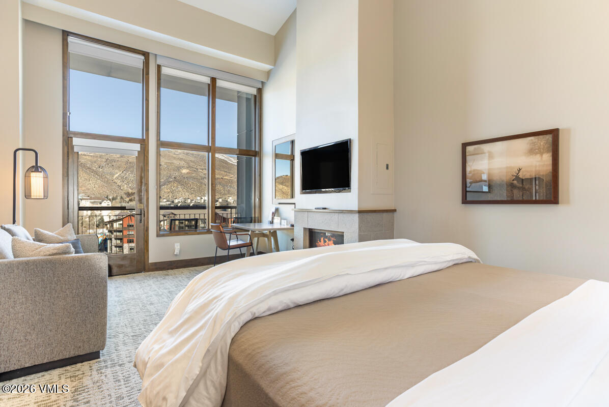 126 Riverfront Lane, Unit 912 Avon, CO 81620 - Photo 11 of 28 a spacious bedroom with a large bed and a flat screen tv