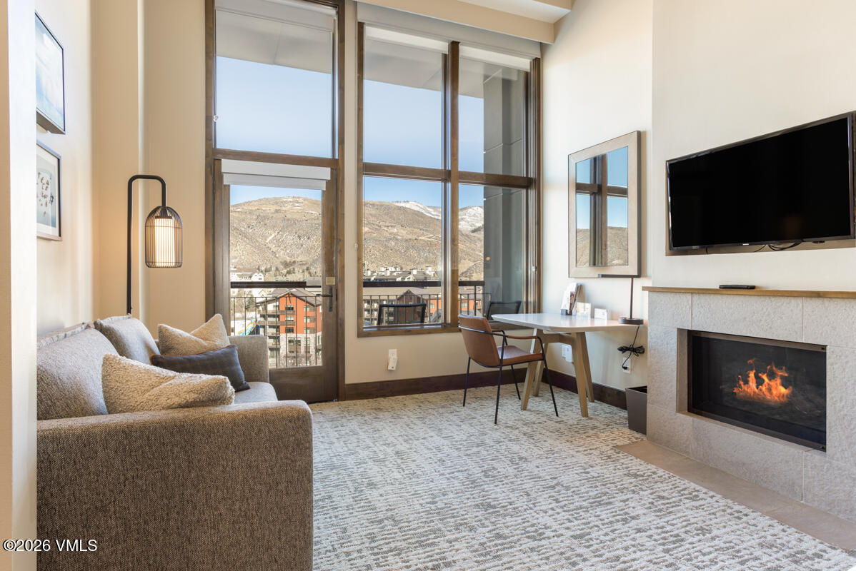 126 Riverfront Lane, Unit 912 Avon, CO 81620 - Photo 12 of 28 a living room with furniture a fireplace and a flat screen tv