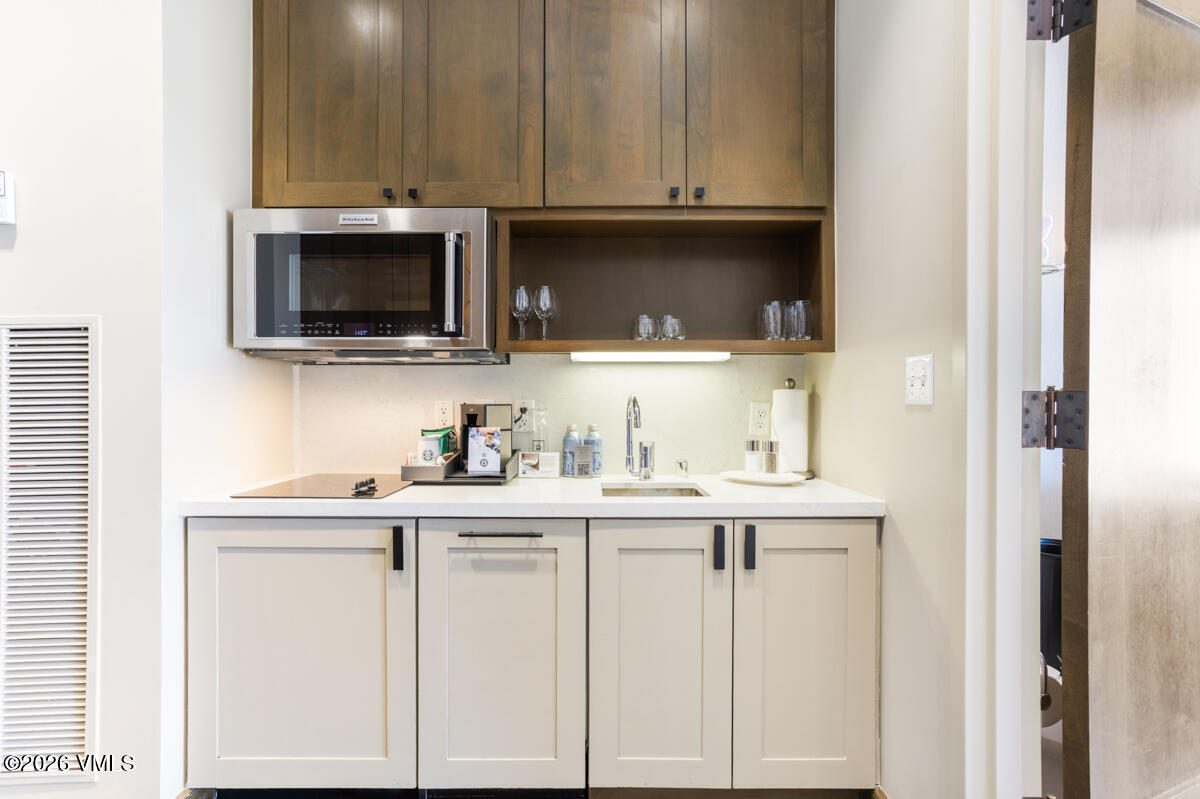 126 Riverfront Lane, Unit 912 Avon, CO 81620 - Photo 23 of 28 a kitchen with white cabinets and a sink