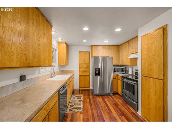 a kitchen with stainless steel appliances granite countertop a refrigerator a sink dishwasher and a stove