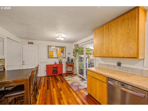a open kitchen with stainless steel appliances granite countertop a sink dishwasher and cabinets with wooden floor
