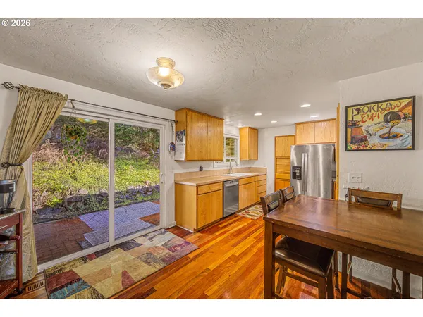 a kitchen with a refrigerator a sink dishwasher with a dining table and chairs