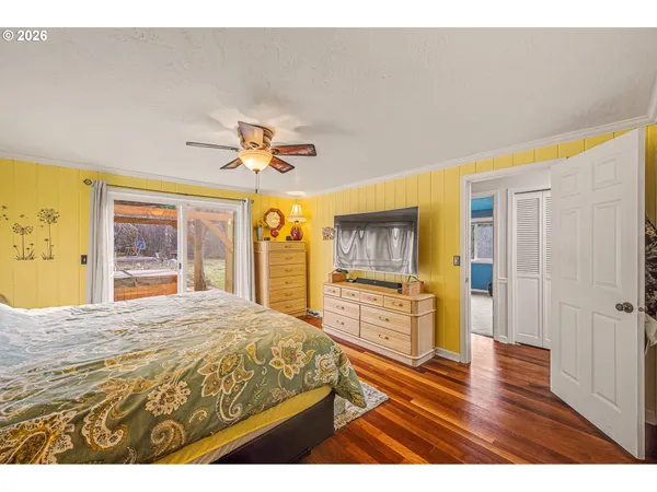 a bedroom with a bed and a flat tv screen on dresser