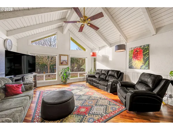 a living room with furniture a floor to ceiling window and a flat screen tv