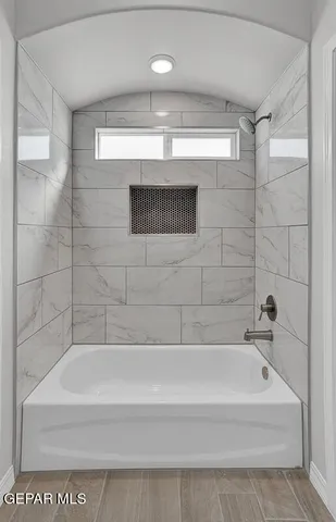 a bathroom with a tub sink and mirror