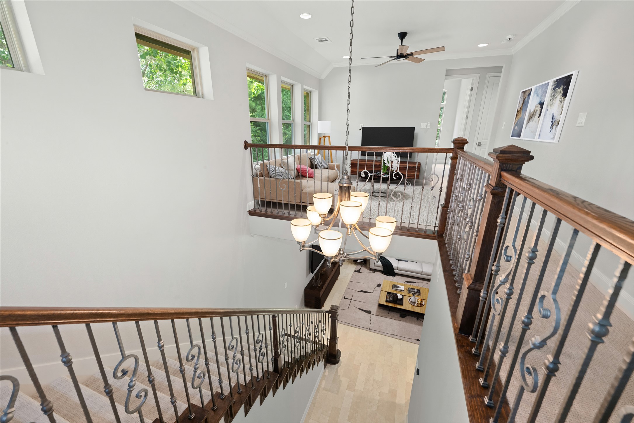 98 Herons Flight Place Spring, TX 77389 - Photo 12 of 29 Dramatic two-story staircase with wrought-iron railings, a statement chandelier, and open sightlines to the living room below. *Virtually Staged