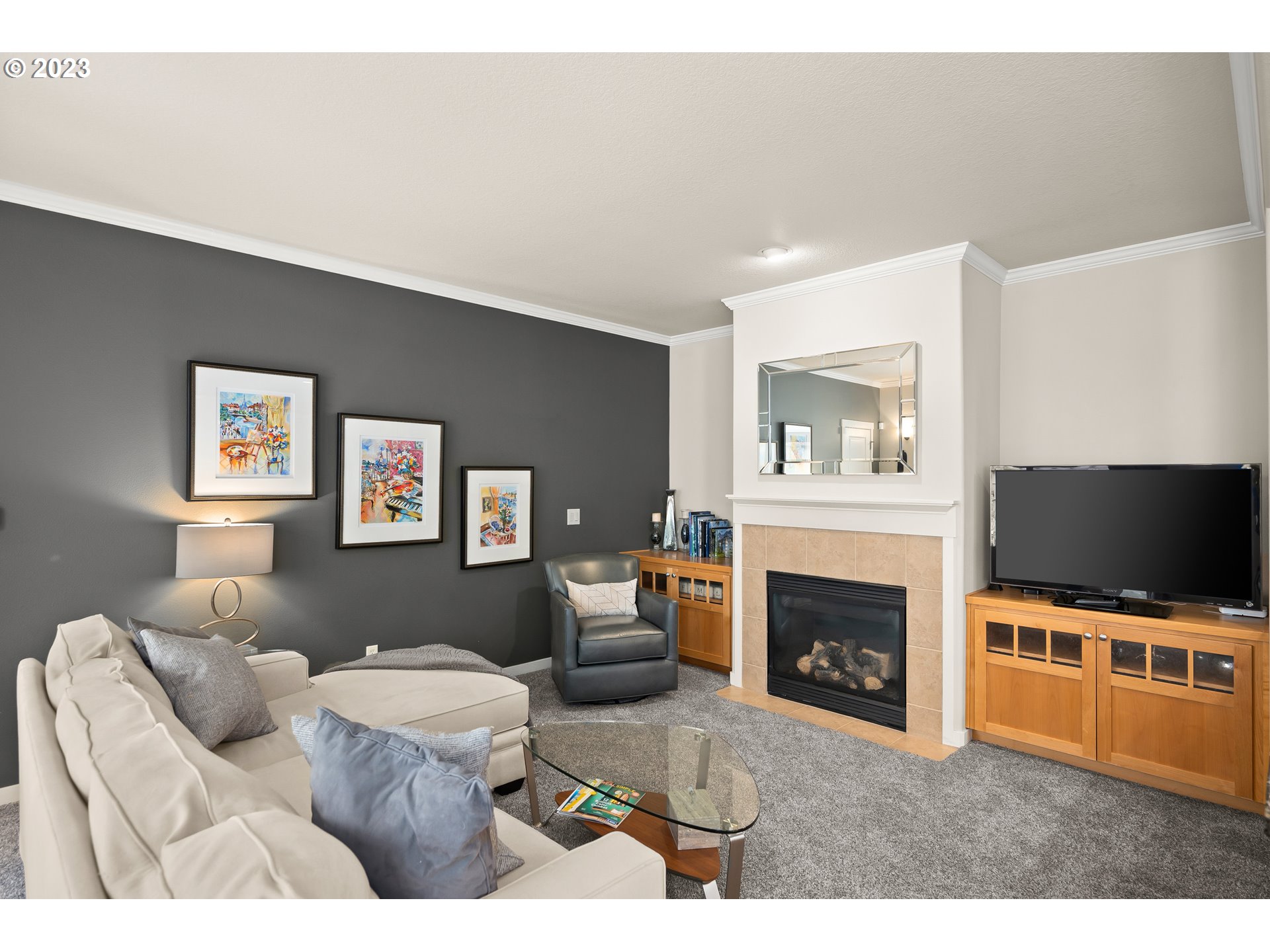 8964 Southwest Taylors Ferry Road Portland, OR 97223 - Photo 12 of 32 a living room with furniture a flat screen tv and a fireplace