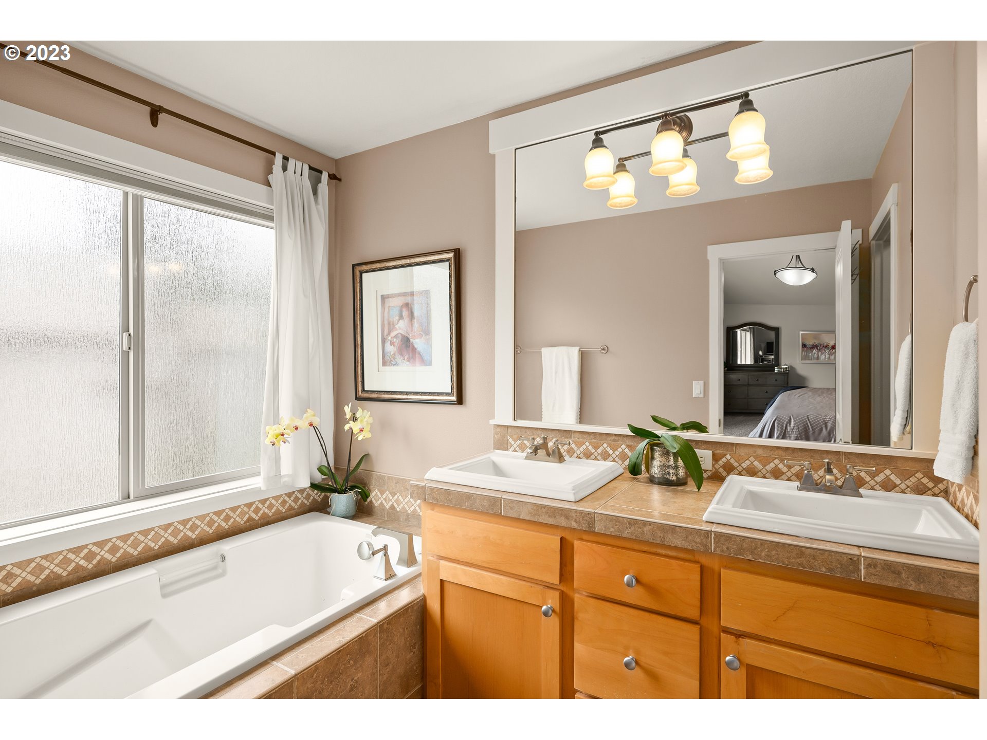 8964 Southwest Taylors Ferry Road Portland, OR 97223 - Photo 21 of 32 a bathroom with a granite countertop sink mirror and a bathtub