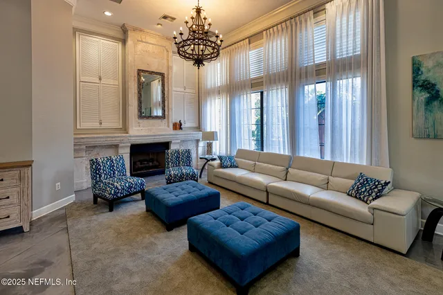 a living room with furniture a chandelier and a fireplace