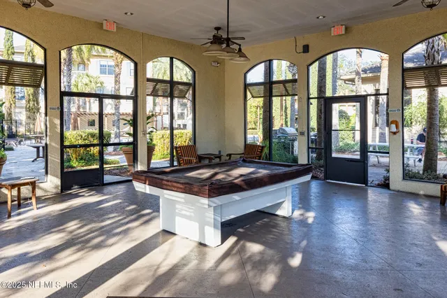 a living room with large windows and a chandelier