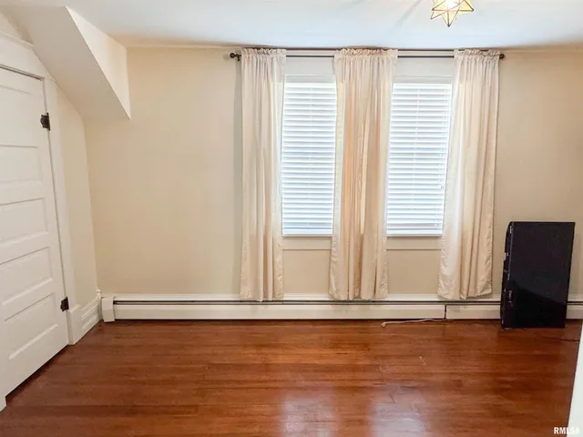 a bedroom with a bed a chair and a window