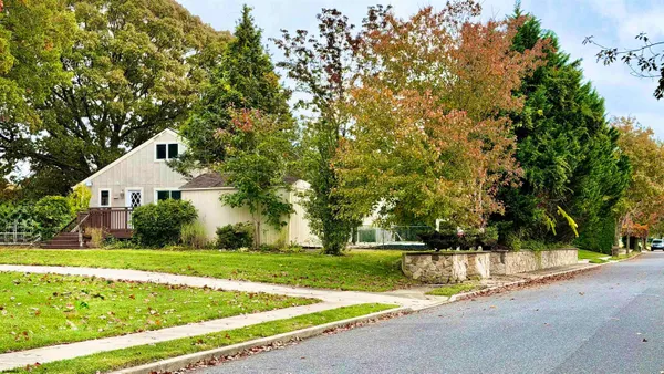a front view of a house with yard and green space