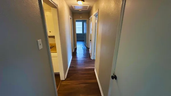 a view of a hallway with wooden floor
