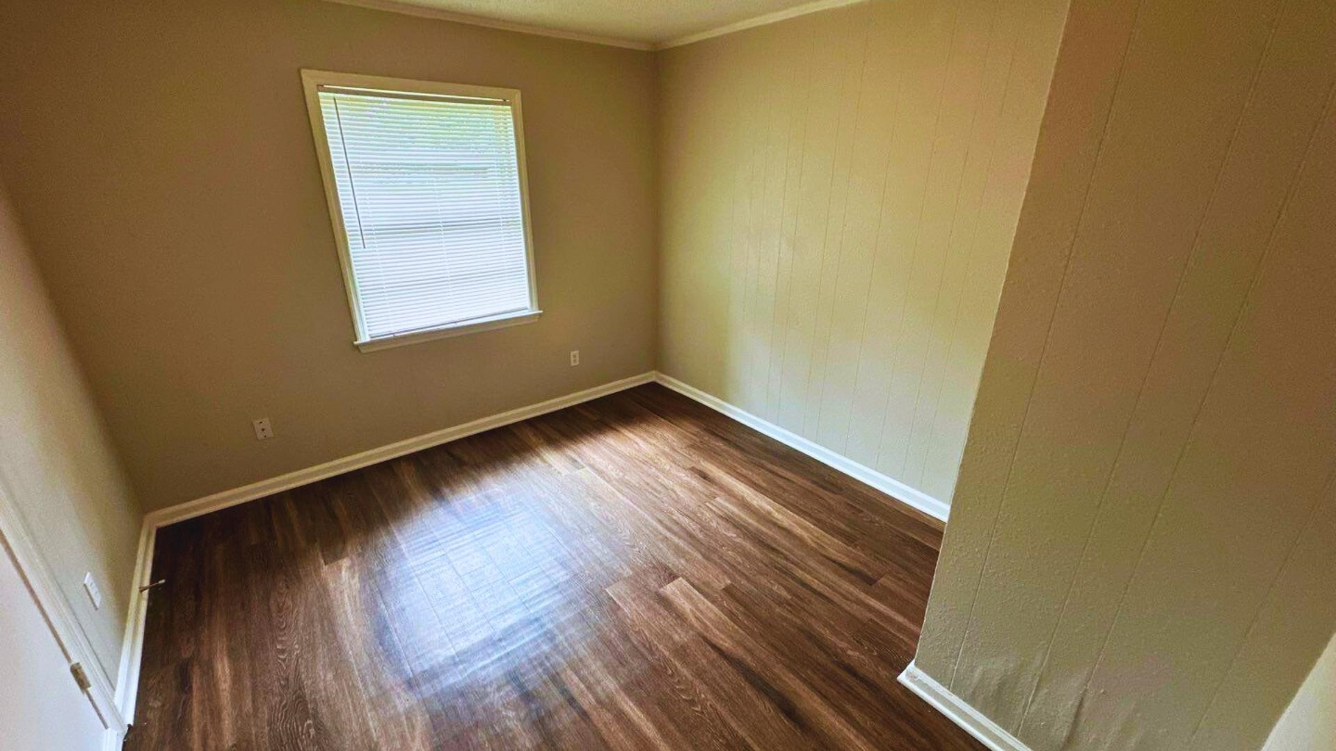 3969 Ridgedale Street Memphis, TN 38127 - Photo 8 of 11 a view of an empty room with wooden floor and a window