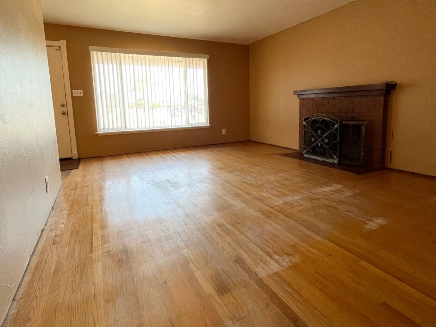 414 Crescent Way Salinas, CA 93906 - Photo 4 of 21 an empty room with wooden floor fireplace and windows