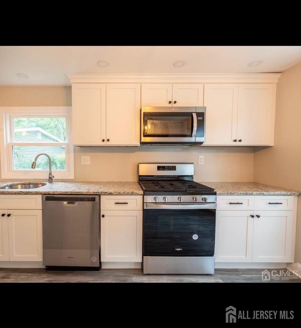 14 Byron Road North Brunswick, NJ 08902 - Photo 6 of 27 a kitchen with stainless steel appliances kitchen island granite countertop a stove a sink and a microwave