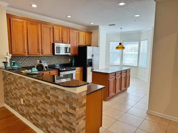 a kitchen with stainless steel appliances granite countertop a stove a sink and a microwave