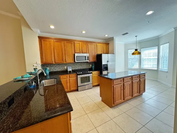 a kitchen with stainless steel appliances granite countertop a stove a sink and a microwave