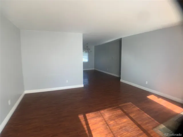 a view of an empty room and wooden floor