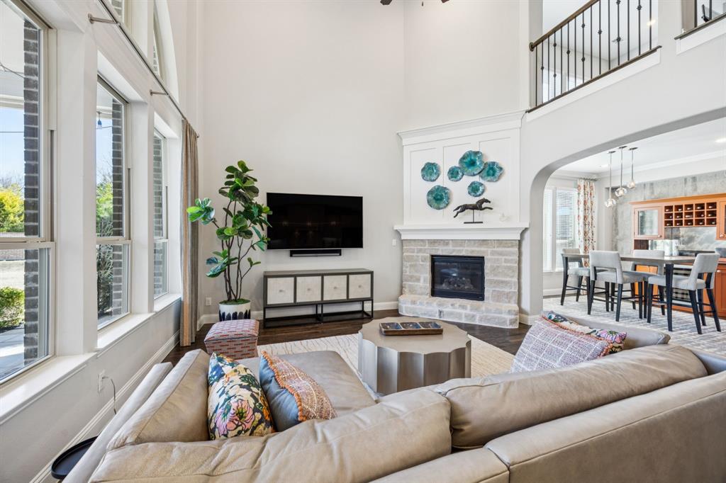 1392 Rolling Thunder Road Frisco, TX 75036 - Photo 11 of 40 a living room with furniture a fireplace and a flat screen tv