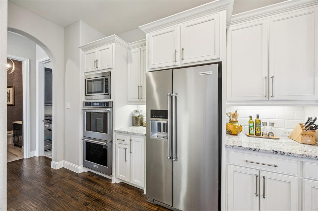 1392 Rolling Thunder Road Frisco, TX 75036 - Photo 17 of 40 a kitchen with stainless steel appliances a refrigerator and cabinets