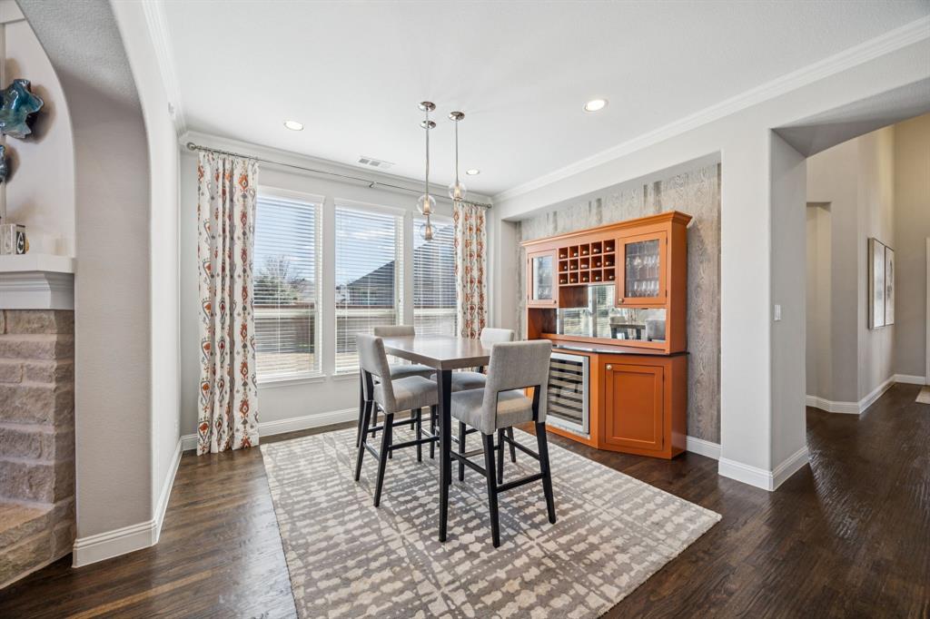 1392 Rolling Thunder Road Frisco, TX 75036 - Photo 9 of 40 a dining room with wooden floor a chandelier a glass table and chairs