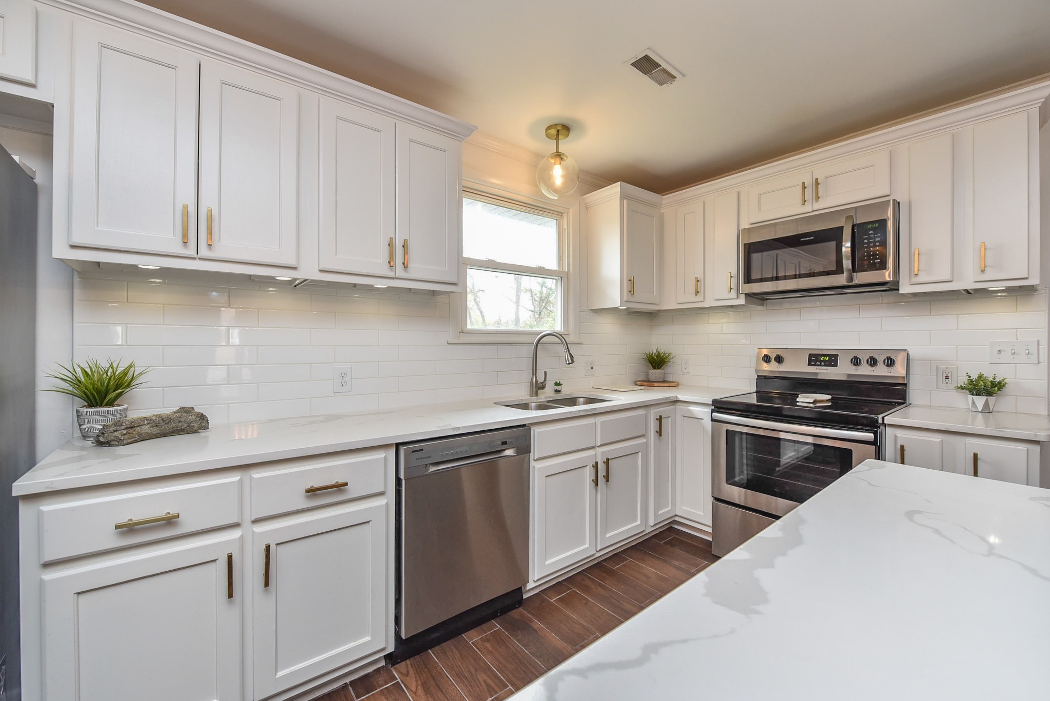 a kitchen with stainless steel appliances granite countertop white cabinets a sink and dishwasher a stove top oven