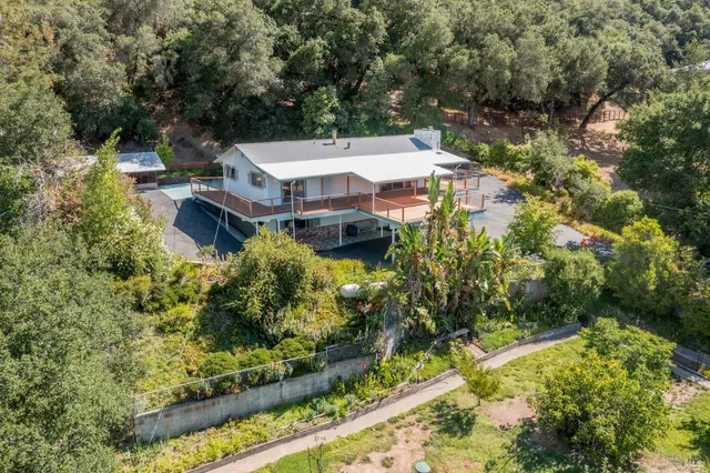 an aerial view of a house with a yard basket ball court and outdoor seating
