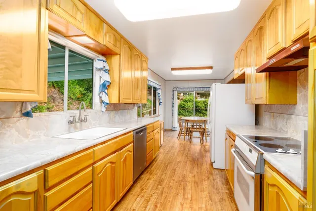 a kitchen with stainless steel appliances granite countertop a sink and dishwasher next to a large window