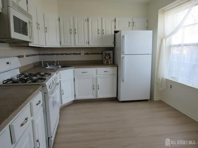 a kitchen with a refrigerator a stove a microwave and cabinets