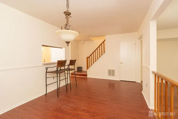 a view of a livingroom with wooden floor and furniture
