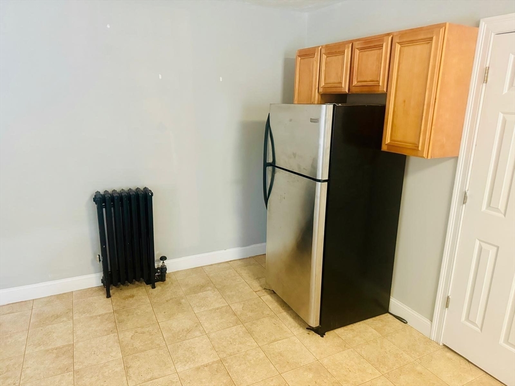 36 Cedar Street, Unit 1A Worcester, MA 01609 - Photo 5 of 19 a view of kitchen with refrigerator and table