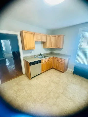 a kitchen with stainless steel appliances a sink a stove cabinets and a window
