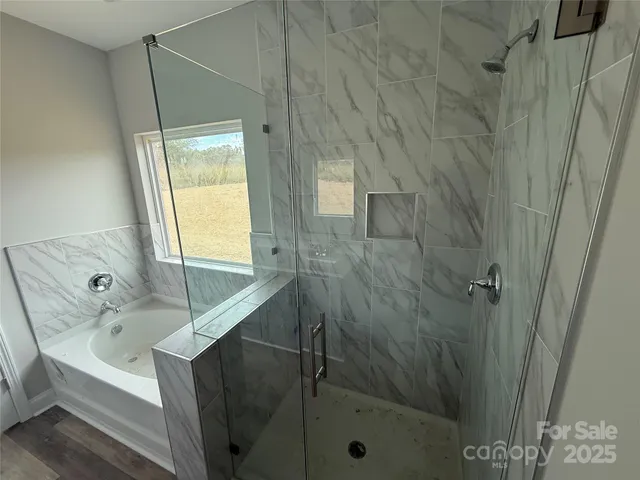 a bathroom with a tub a sink and a window